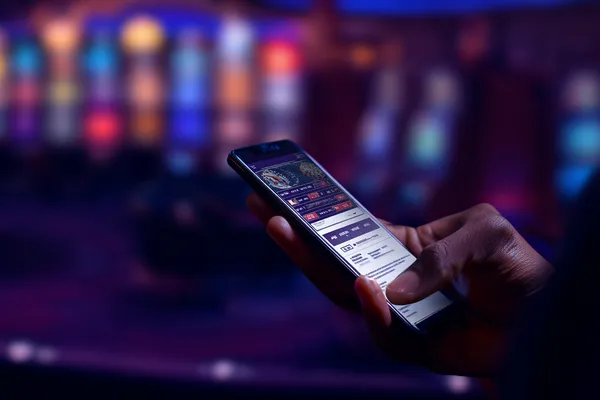 A person using their device against a moody casino-themed background, illustrating the smooth re-entry process at 26JLPH.
